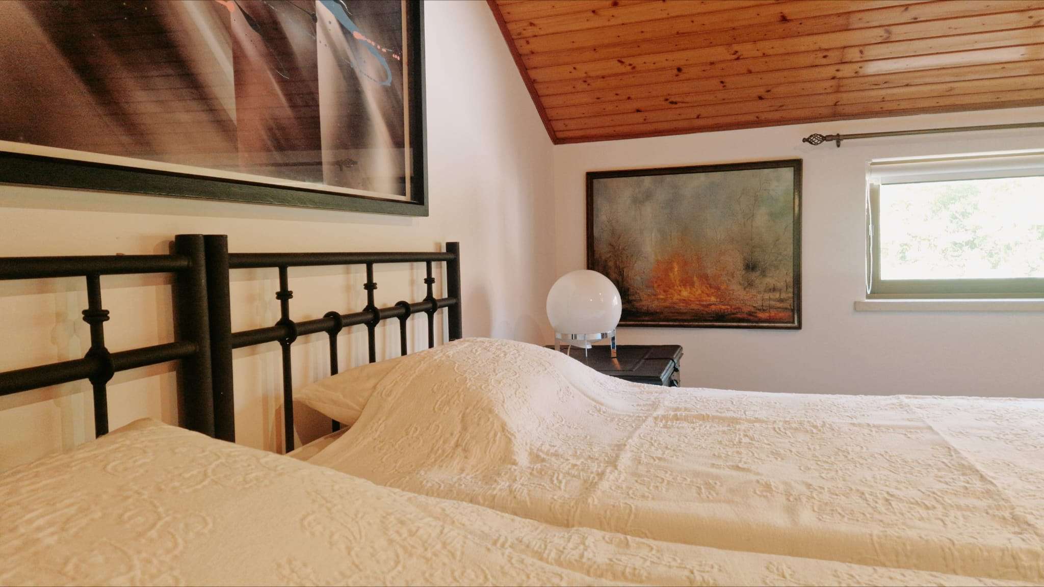 Camas individuais lado a lado num quarto com teto de madeira