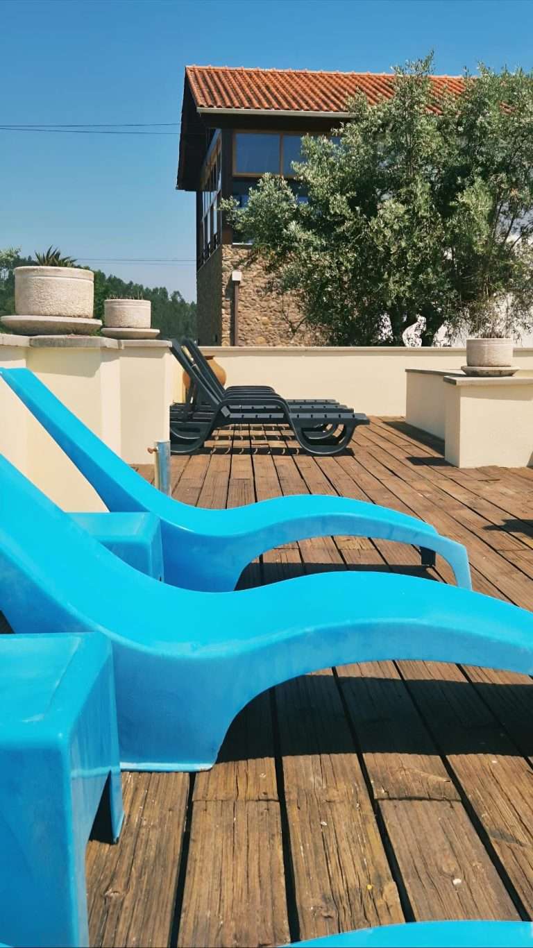 Espreguiçadeiras azuis no terraço junto à piscina