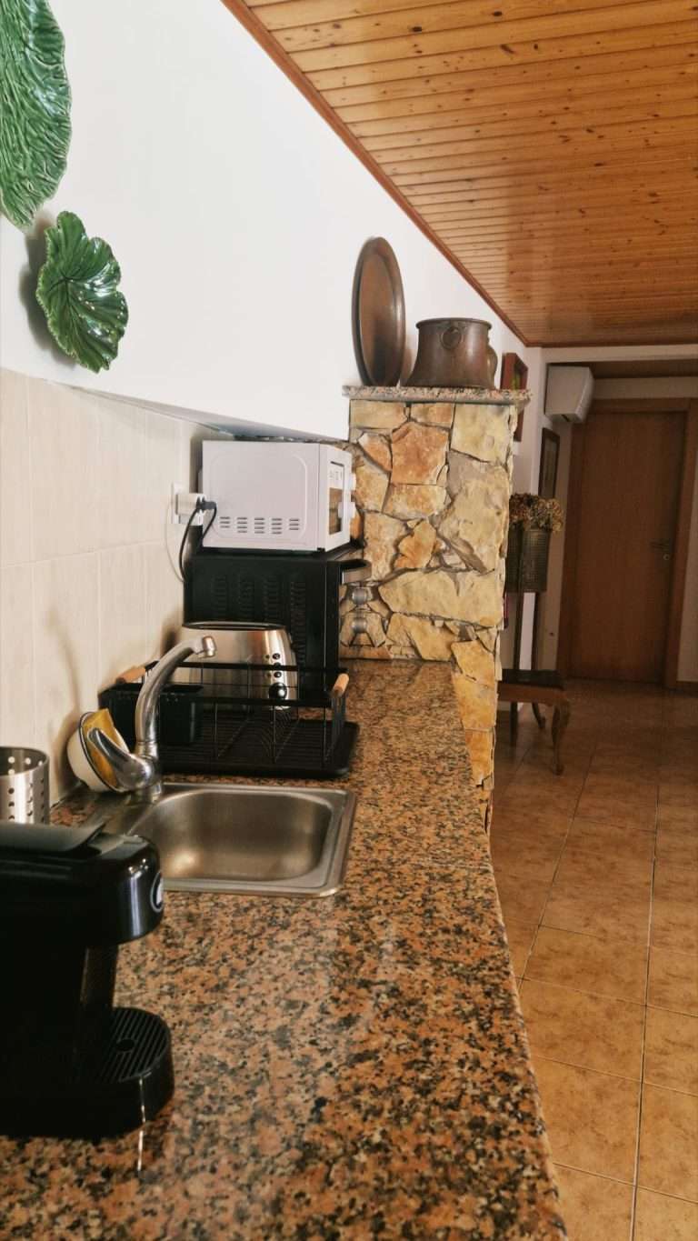 Bancada da kitchenette com lava-loiça e máquina de café