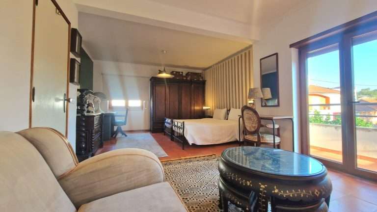 Zona de estar do quarto junto às portas para o exterior