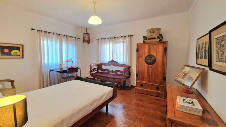 Quarto com camas individuais, cómoda e espelho