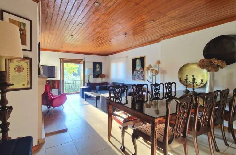 Mesa de jantar ampla e lareira na sala com teto de madeira
