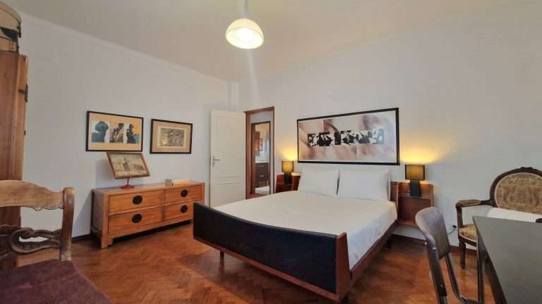 Quarto com cama de casal, cómoda e espelho