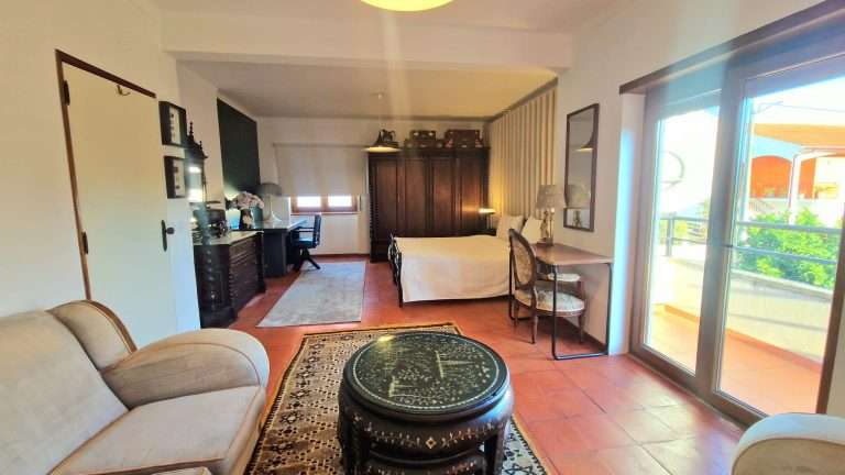 Quarto espaçoso com sofás e acesso ao terraço