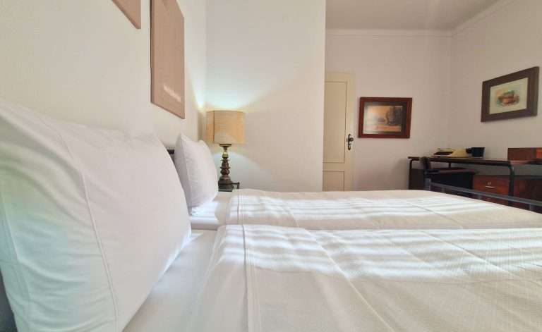 Pormenor das camas individuais com roupa de cama branca