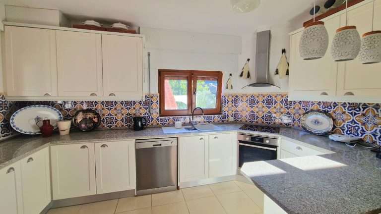 Bancada da cozinha com lava-loiça, forno e azulejos